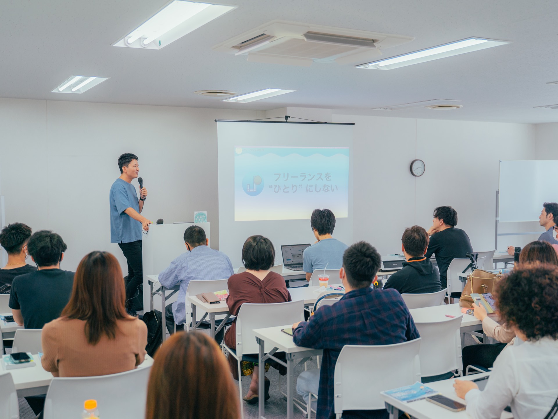 フリーランスの学校のセミナー会場。登壇するしゅうへいと受講生たち